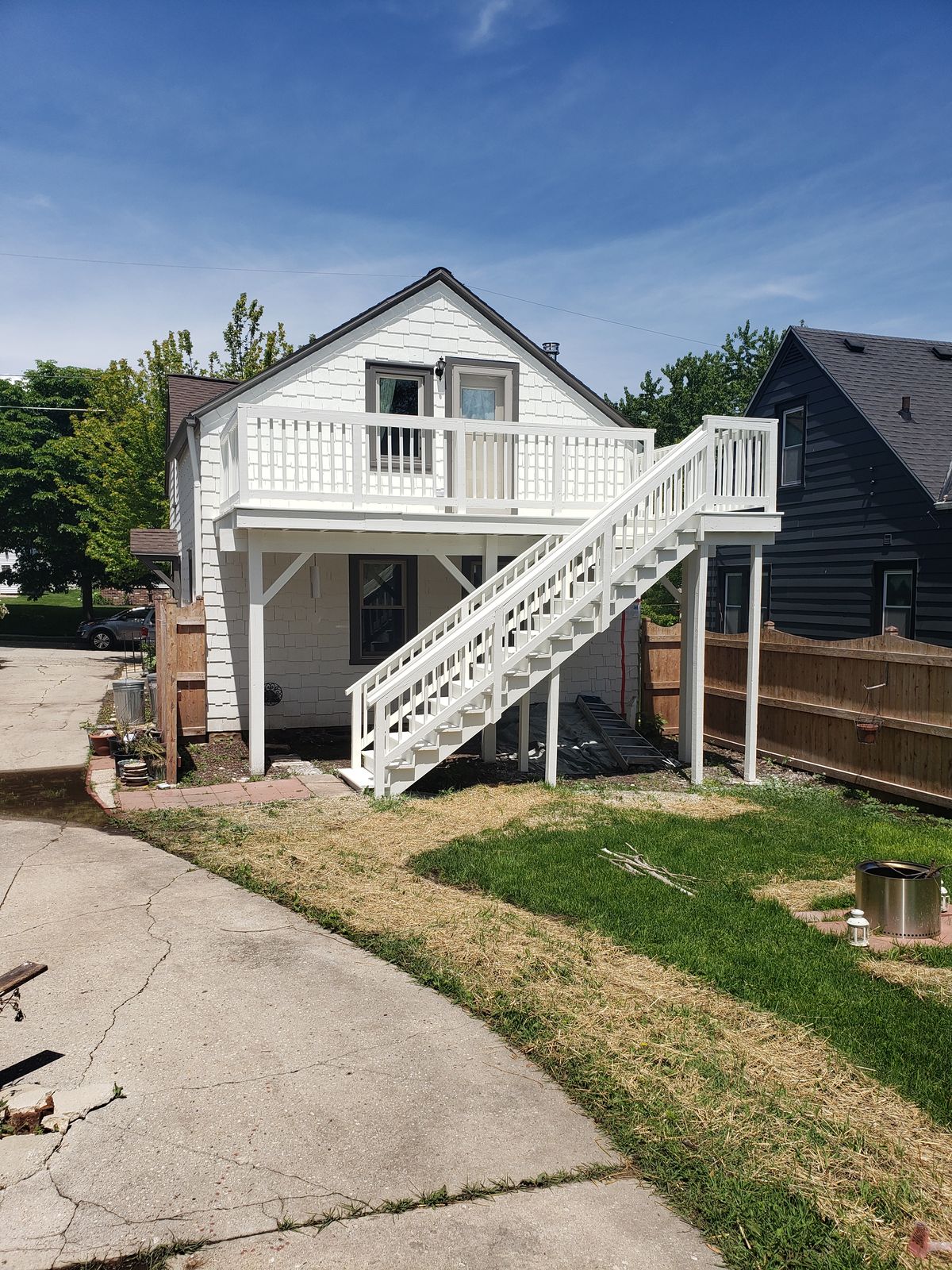 Carriage house with freshly painted siding, deck, railings and stairs